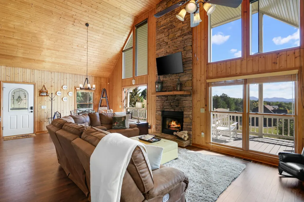 Great room with the gas fireplace lit and the deck doors open to the mountains